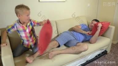 年轻的父亲和小儿子在沙发上用枕头<strong>大战</strong>的慢镜头，美妙而有趣的时光
